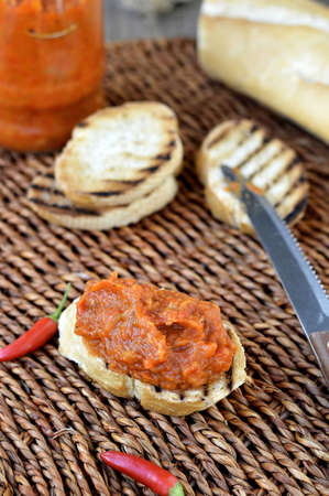 Bruschetta  crouton  with relish of baked red peppers and eggplants on a wicker round の写真素材