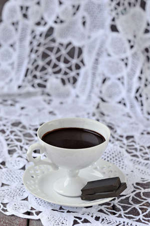 Hot chocolate in a white cup and saucer elegant with chocolate pieces on a white background  Still life の写真素材