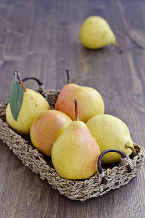 Ripe pears in a basket on a wooden table  Close up の写真素材
