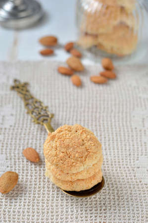 Homemade cookies with almonds and decorations  spoon, glass cookie jar, almond kernels の写真素材