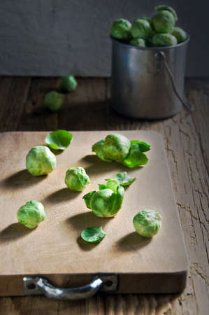Still life of fresh green Brussels sprouts in a metal container on a wooden background. Selective focusの写真素材