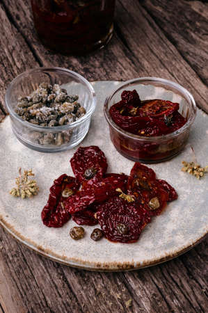 Delicious Sun Dried Tomatoes with Capers and Oregano in a glass jar. Traditional Italian food vegetables.の写真素材