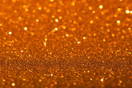 Golden festive background with sparkles in the bokehの写真素材