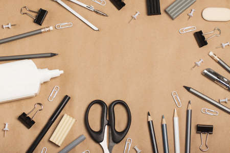 School or office supplies in black, gray and white colors on a craft background. The concept of minimalism, creativity, learning, work. Flat layの写真素材