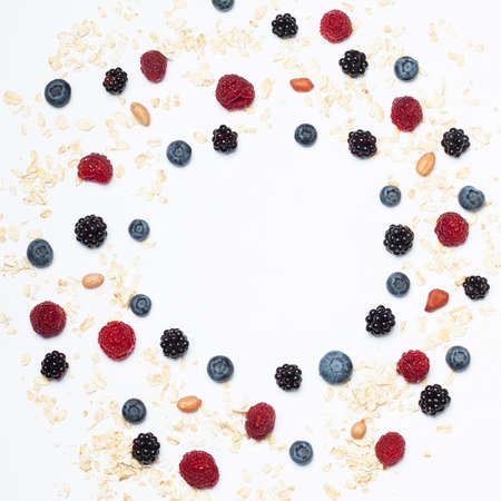 Set for a healthy breakfast as a circle frame. Raspberries, blueberries, blackberries, peanuts and oatmeal.の写真素材
