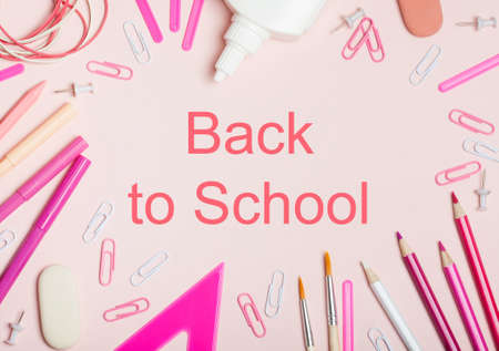 School supplies of pink and white colors on a pink background. Female or girlish still life on the topic of school, study, office work. Flat layの写真素材
