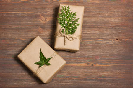 Gifts packed in a minimalistic style on a wooden background. The concept of stylish, minimalistic...
