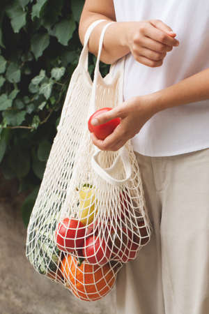 Vegetables in an eco bag and girls hands