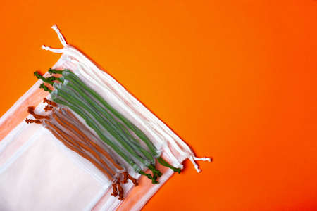 Set of reusable eco bags different sizes on a trendy orange background. An alternative to plastic bags. Zero waste concept, plastic-free, eco-friendly shopping. Copy spaceの写真素材