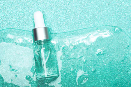 Face serum close-up on the trendy mint background. Collagen, hyaluronic acid for skin care. Achievements of modern science in cosmetic to preserve beauty. Copy space.の写真素材