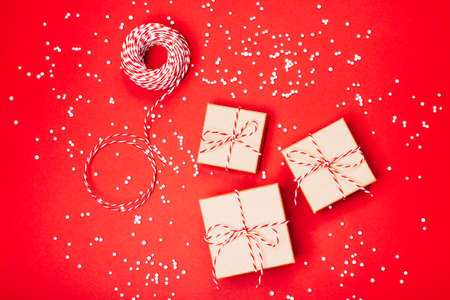 Minimalistic Christmas gift wrapping on the red background. Flat lay. Merry Christmas, New Year,...