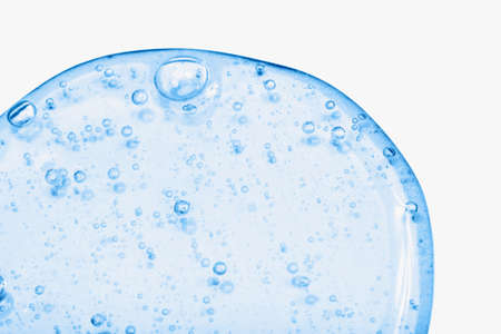 Close-up of serum or cosmetic gel in trendy blue color. The drop isolated on the white background....