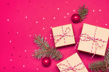 Christmas composition with gifts, branches and holiday elements on the pink background. Flat lay. Merry Christmas, New Year, winter concept.の写真素材