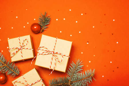 Christmas composition with gifts, branches and holiday elements on the orange background. Flat lay. Merry Christmas, New Year, winter concept.の写真素材
