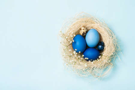 Easter eggs in blue colors in a nest. Copy space. The concept of stylish decoration for Easter, greeting cards, etc. Flat layの写真素材
