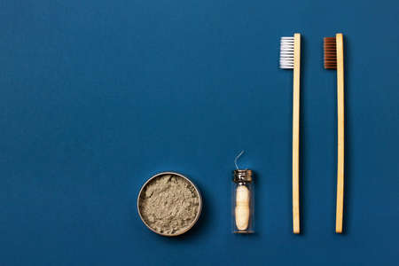 Set of eco-friendly tooth care items on the blue background. Bamboo toothbrush, organic tooth powder and natural dental floss. Zero waste concept, plastic-free, organic, eco-friendly shoppingの写真素材