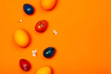 Easter eggs in trendy colors on the orange background. The concept of stylish decoration for Easter, minimalistic, greeting cards, etc. Copy space.の写真素材