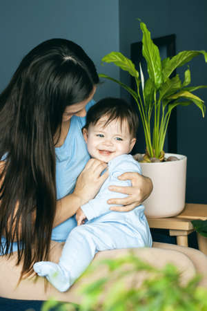 Mother plays of her baby. The baby is laughing. The concept of communication between parents and children, motherhood, the formation of affection.の写真素材