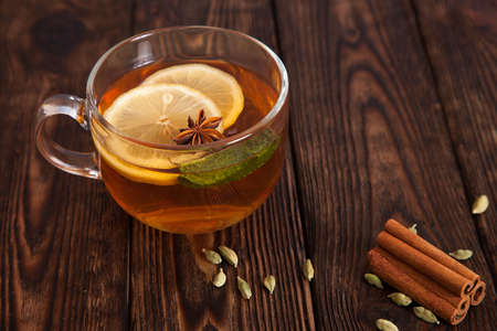 hot tea with lemon and spices on a wooden tableの写真素材