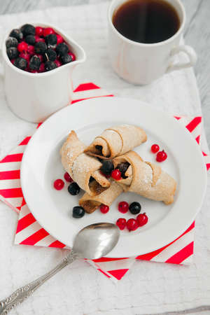 sweet bagels cookies and berries on a plate with two white cupsの写真素材
