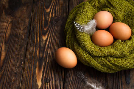 natural eggs in nest woven on wooden backgroundの写真素材