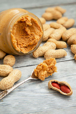 an open jar of peanut butter with spoonの写真素材