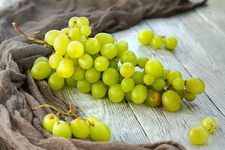 bunch green grapes on a grey wooden backgroundの写真素材