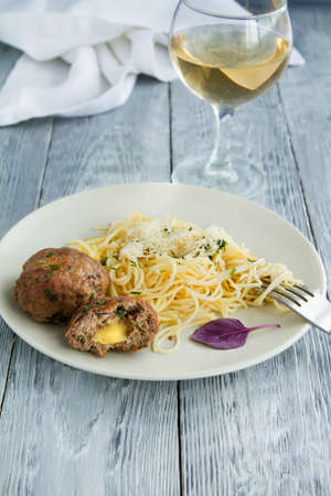 Hearty lunch from pasta spaghettii and a glass of white wine in a restaurant