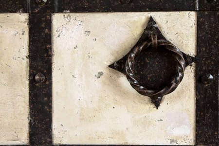 Background, texture of old stone and metal. A fragment of an old ancient door from a historic...