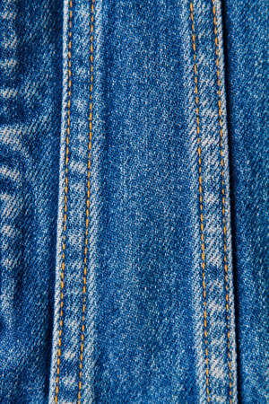 part of blue worn denim jeans close-up, background