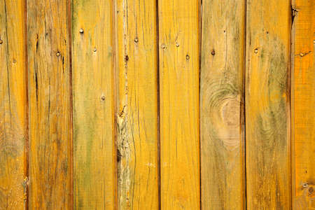 Old wood background with shabby yellow paint. Vintage texture of the wooden wall.の写真素材