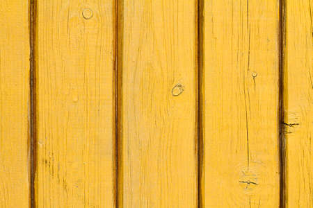 Old wood background with shabby yellow paint. Vintage texture of the wooden wall.の写真素材