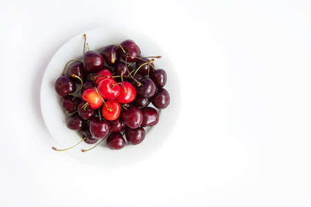 Large big plate with dark cherries and red cherries on white backgroundの写真素材