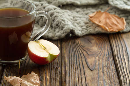 glass Cup with a hot drink with a sliced Apple on a wooden background. Autumn compositionの写真素材