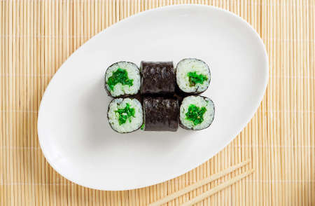small sushi roll and two cap of tea on a wooden table top view.の写真素材