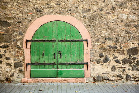 vintage grange wooden green door in stone wallの写真素材