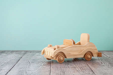 wooden vintage toy car on a blue and wooden backgroundの写真素材