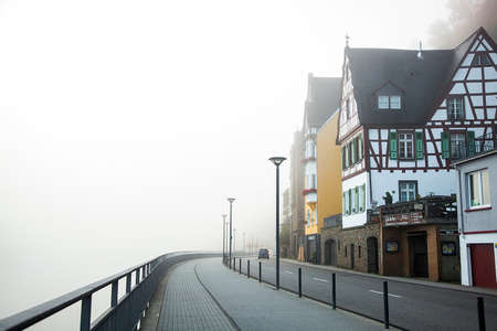 Germany, autumn. Street of town and promenade in the morning fog