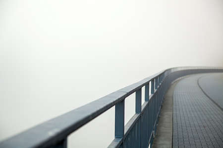 Iron bridge with paving stone in strong fog. Minimalism in the urban landscapeの写真素材