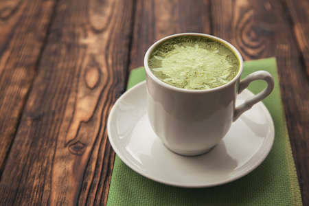 one cup of matcha green tea latte on wooden bakground.Copy spaceの写真素材