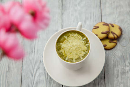 cup of green latte and some cookies with matcha top view