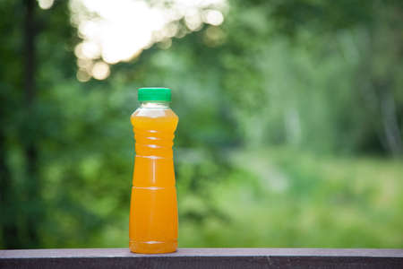 delicious citrus juice in a plastic bottle on the background of summer natureの写真素材