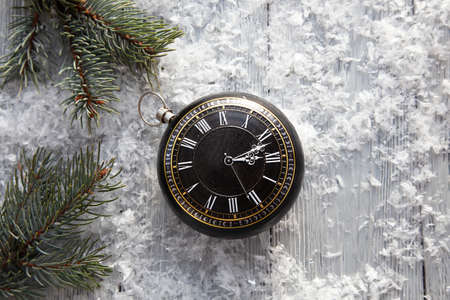 clock in the form of Christmas toys on a snowy background with spruce branches. The Concept Of...
