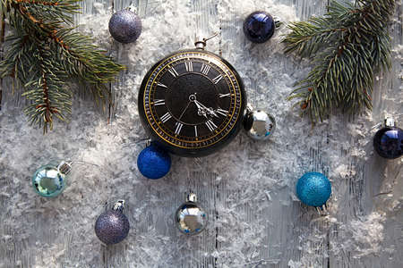 Scattered Christmas toys and clock on a gray snow-covered wooden table. The view from the top....
