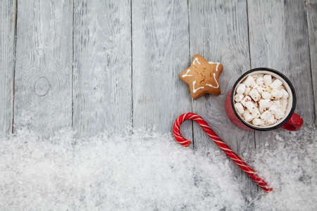 Christmas candy cane and gingerbread on snowy background top view .Greeting card on Christmas and...