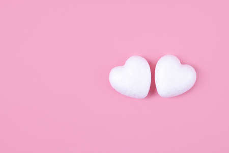 Two little white hearts on a pink background