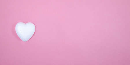 One little white heart on a pink backgroundの写真素材