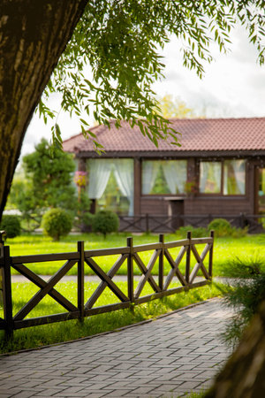 Wooden modern fence along the stone path leading to the summer house. Summer vacation in a country house. Summer rest.の写真素材