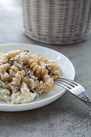 Delicious dish fusilli pasta with creamy mushroom sauce on a gray stone tableの写真素材