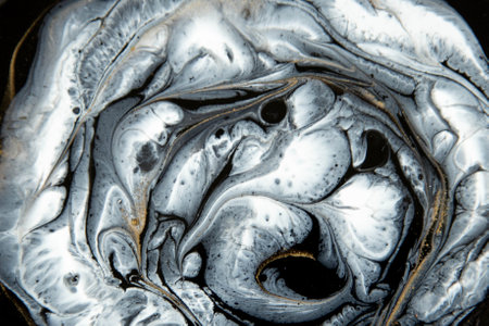 Abstract painting with epoxy resin. Marble circles in black, white and gold colors. Abstract modern veined liquid background for design.の写真素材